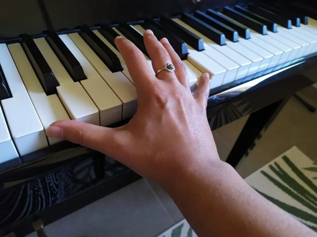 Main étirée sur le clavier pour jouer une octave