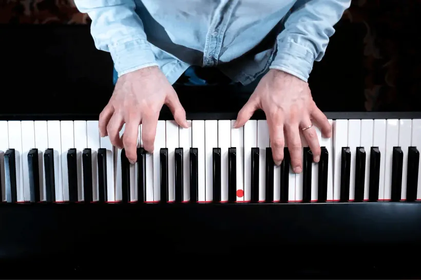 Vue du dessus des mains de Cyrille sur les touches d&rsquo;un clavier