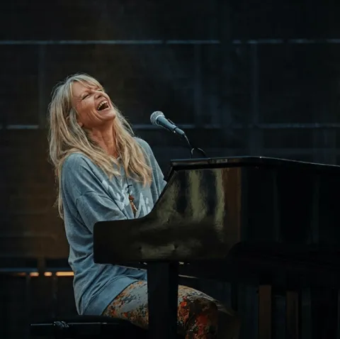 Une MyPianiste chante en s&rsquo;accompagnant au piano, visiblement heureuse de jouer