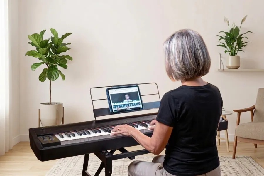 Une MyPianiste suit une leçon MyPianoPop sur sa tablette, à son clavier, dans son salon